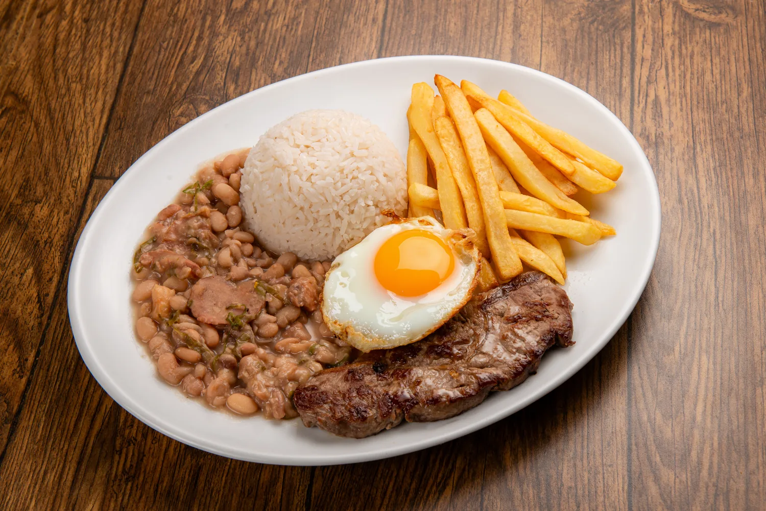 Contra filé paulista da casa com ovo de gema brilhante, tutu de feijão, arroz e fritas