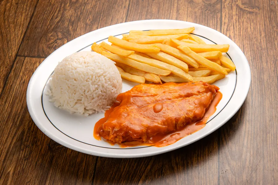 Pescado grelhado servido com capricho sobre mesa de madeira